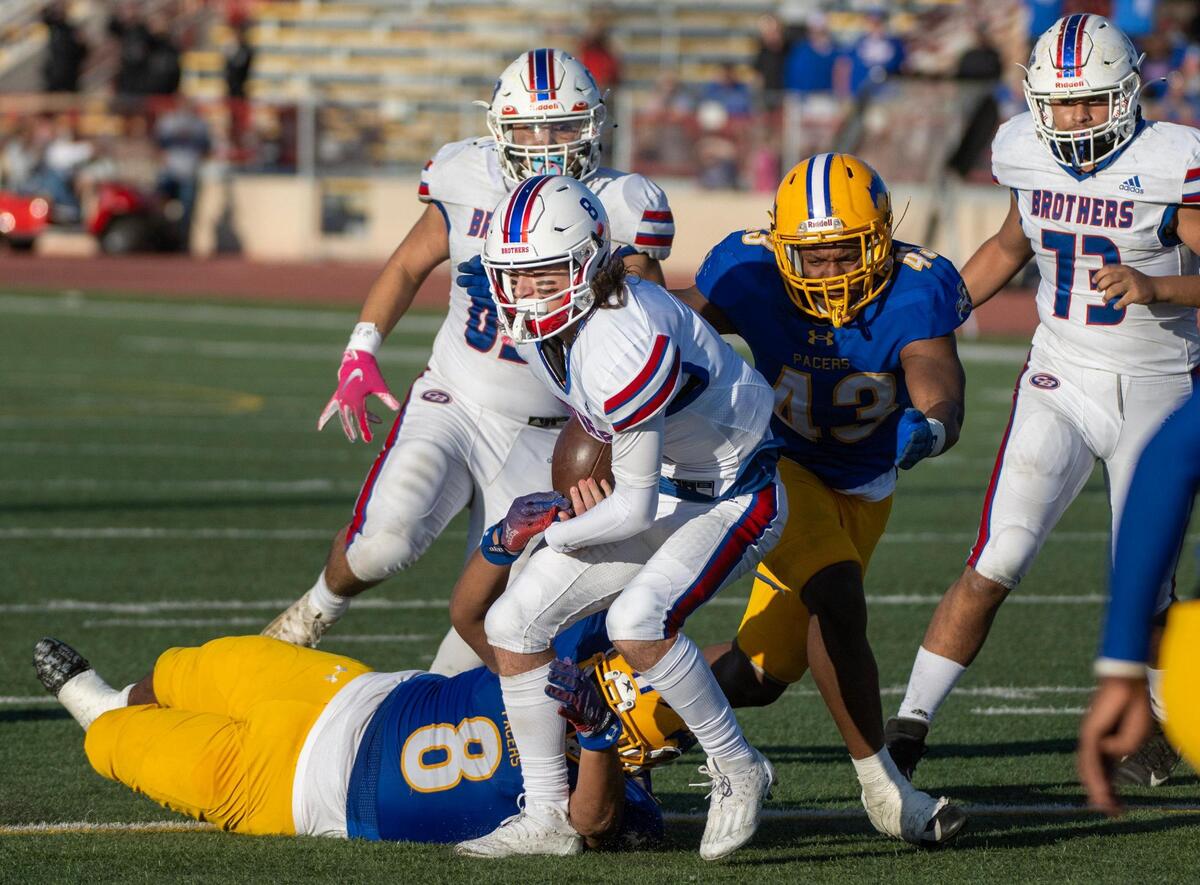 Christian Brothers quarterback William Littlejohn is tackled by Grant High School’s Soanae Taamai and Marque Green Jr. in the fourth quarter during the CIF Sac-Joaquin Division III section championship at Hughes Stadium in Sacramento on Friday.