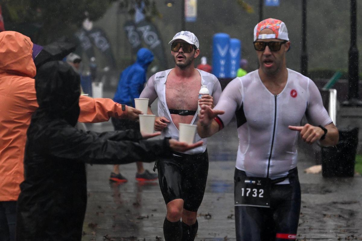 Runners grab water from volunteers during the Ironman California triathlon on Sunday.