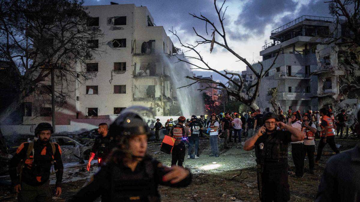 Israeli security personnel and first responders inspect an area hit by an Iranian missile strike on central Tel Aviv on June 16, 2025.