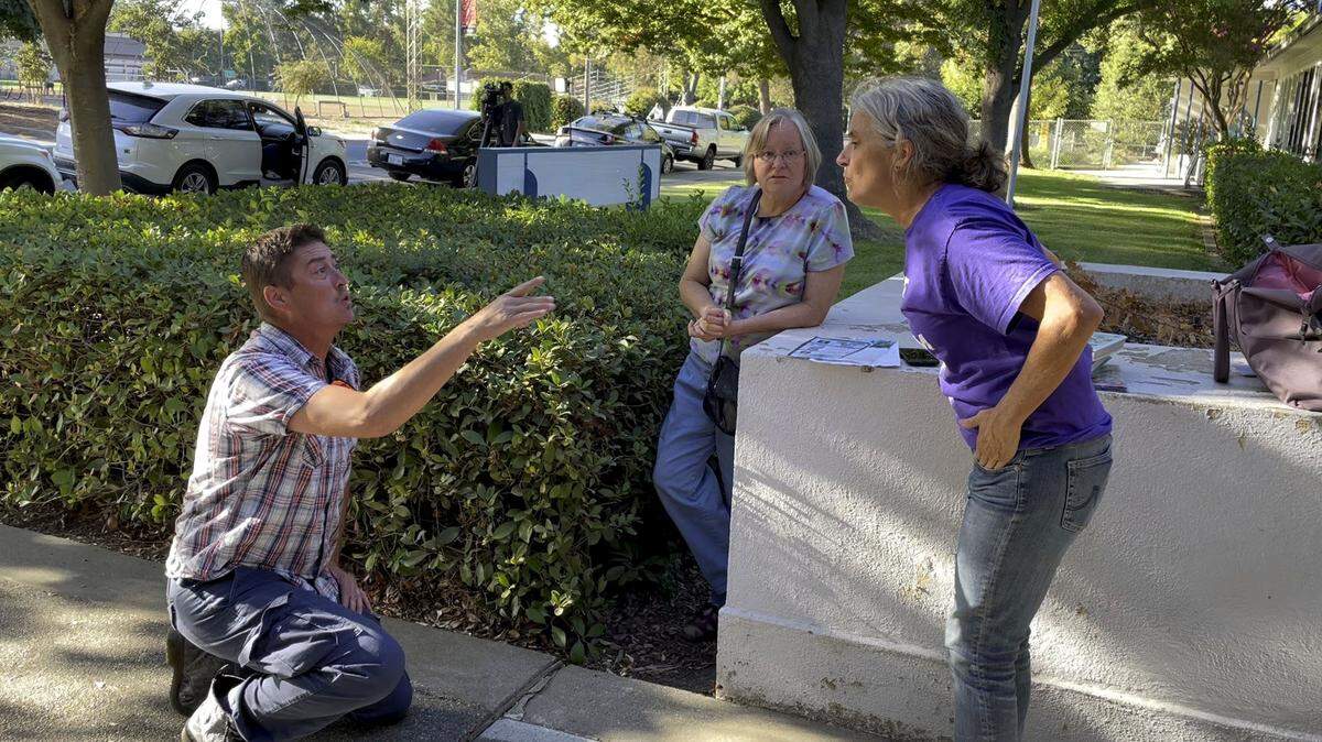 Liam Taylor, left, argues with Yolo County Moms for Liberty chapter chair Beth Bourne outside a closed-door meeting at the Davis Joint Unified School District offices Sept. 26, 2023, as board members met behind closed doors with police over a series of bomb threats that have disrupted schools since August.