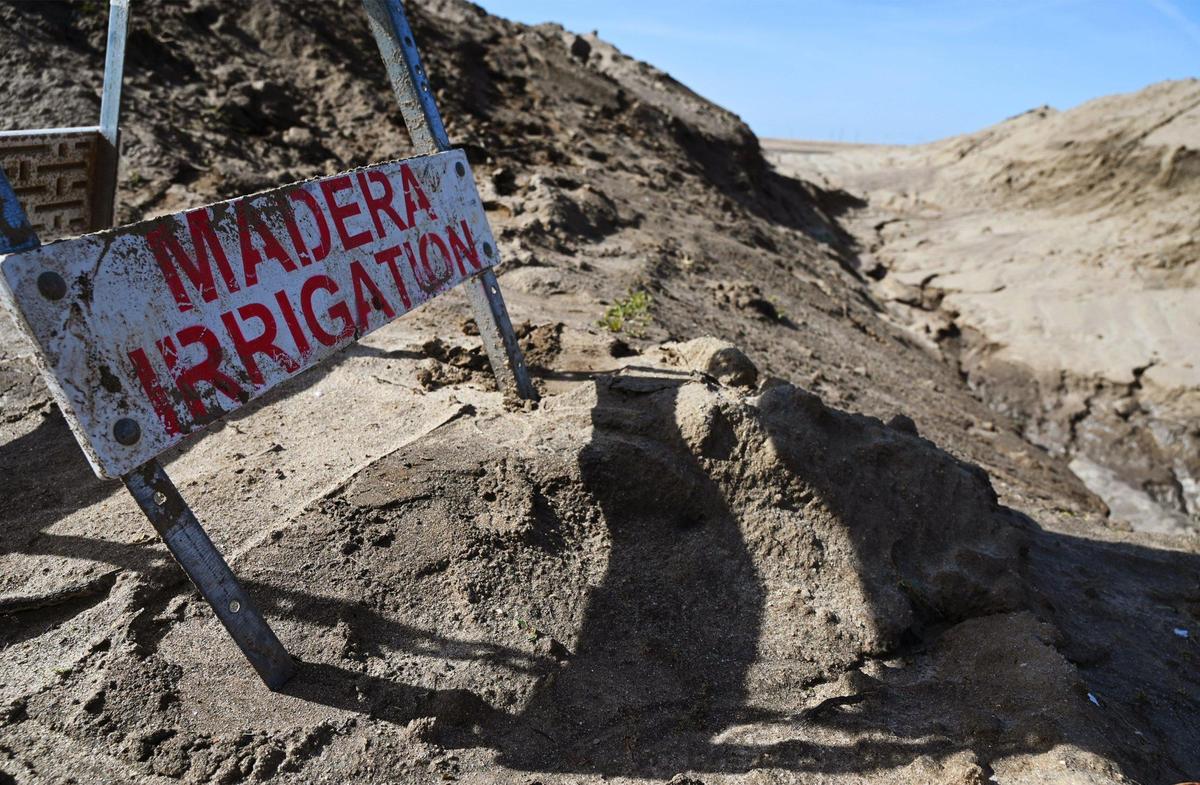 A Madera Irrigation District sign is seen at a corner of a 20-acre basin constructed on land operated by Markarian Family LP in hopes of recharging the local aquifer. The recharging basin is adjacent to another 20 acres for a future basin. Photographed Friday, March 3, 2023 near Madera.