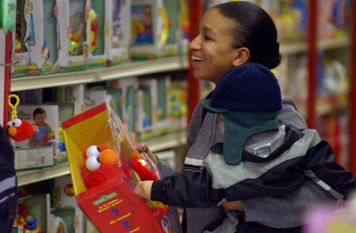 Taniel Washington, with her son 11-month-old son Elijah Muller, picks out an Elmo while Christmas toy shopping at KB Toys on Truxel Road in 2001.