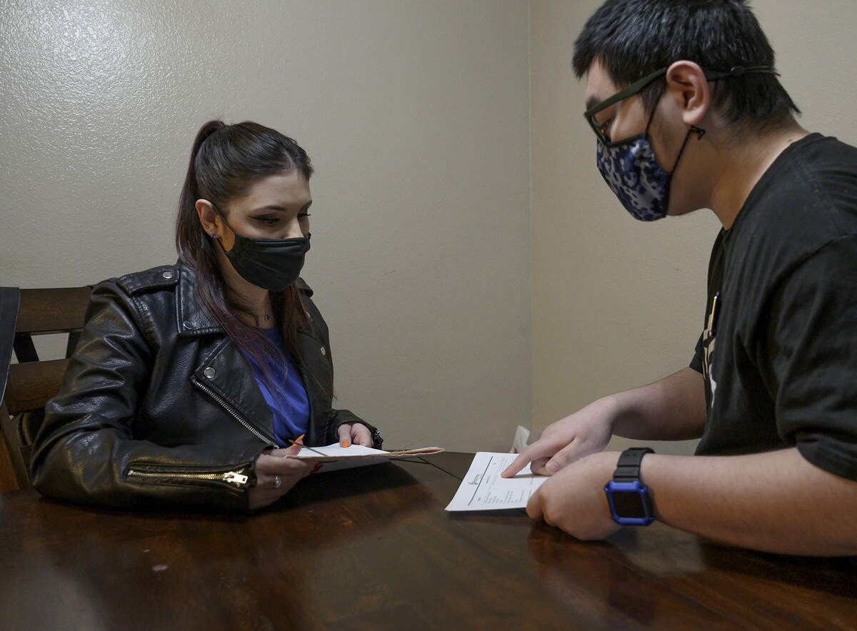 Aspiranet life coach Courtney Gilbertsen helps client Jordan Wang with some paperwork at his apartment on Nov. 17. Aspiranet’s overall goal is to offer temporary financial support and to teach life skills so people like Yang will not fall into homelessness. The agency pays the rent for him and another young former foster youth.