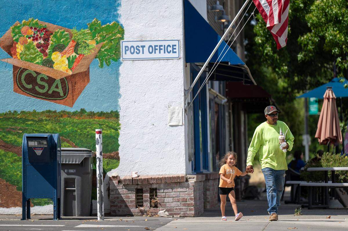 A man walks down Yolo Avenue in Esparto after buying ice cream on Thursday, July 3, 2025.