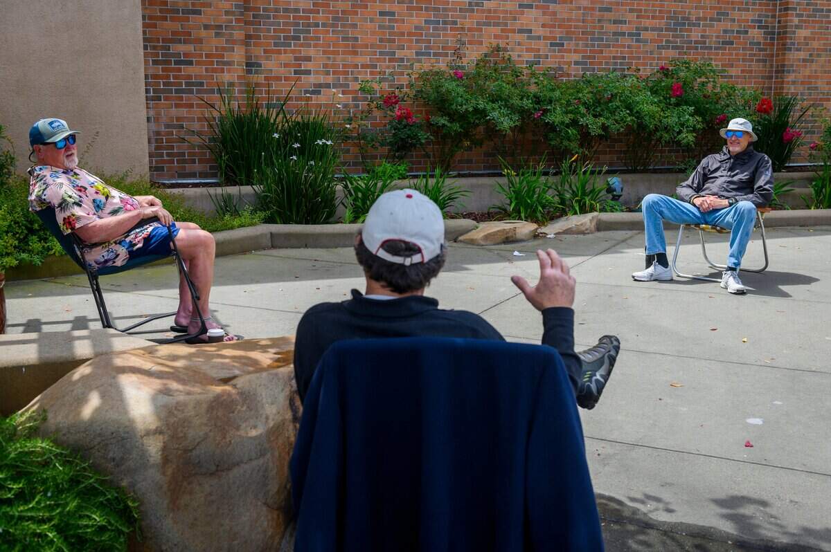 Dennis Fox, middle, talks to his friends Doug Stryker, right, and Brad Baier as they social distance in front of the Whole Foods at Fountains at Roseville on Monday, May 18, 2020. Stryker says that the group of retired teachers have been meeting at Fountains on Mondays for the past 5 years. They continue to meet and have been social distancing since the practice was recommended.