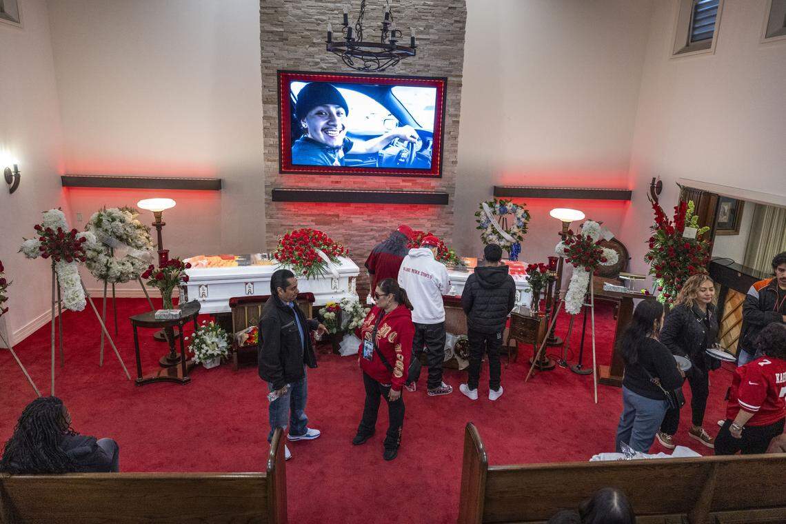 Mourners pay their respects to Jesus and Jhony Ramos, brothers killed in the Esparto fireworks explosion, during a wake on Sunday, July 27, 2025, in Daly City. A photo of Jhony is displayed on a screen.