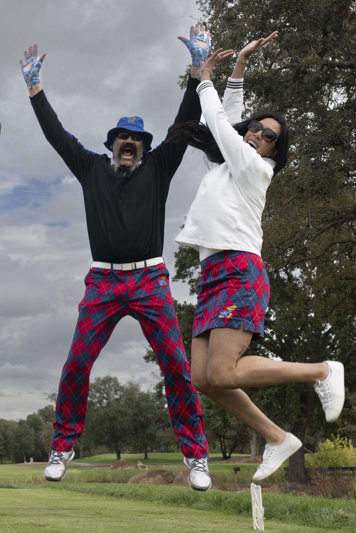 Former Sacramento Kings player Scot Pollard and his wife Dawn jump in the air during the Phil Oates Celebrity Golf Classic in Granite Bay on Monday. Pollard received a life-saving heart transplant last year. 