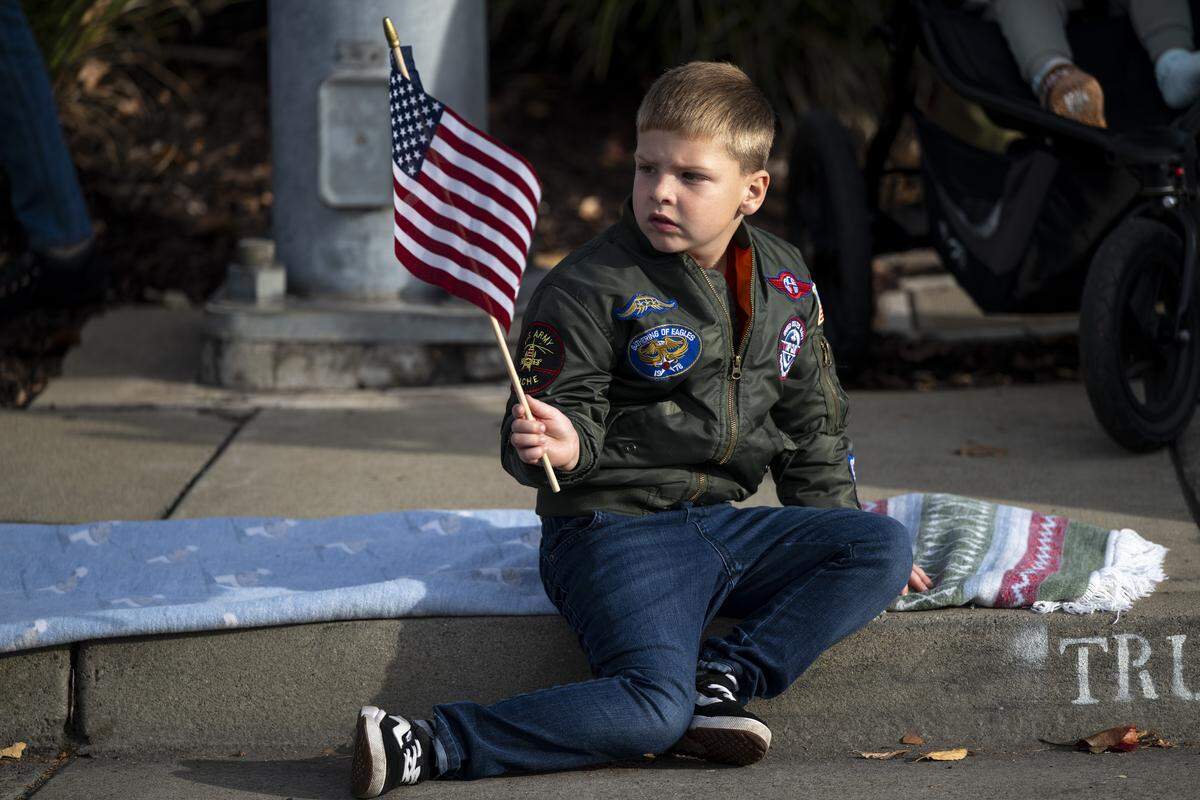 Lucian Schablaske, 5, waves an American flag during a Veterans Day parade in Folsom on Tuesday, Nov. 11, 2025.
