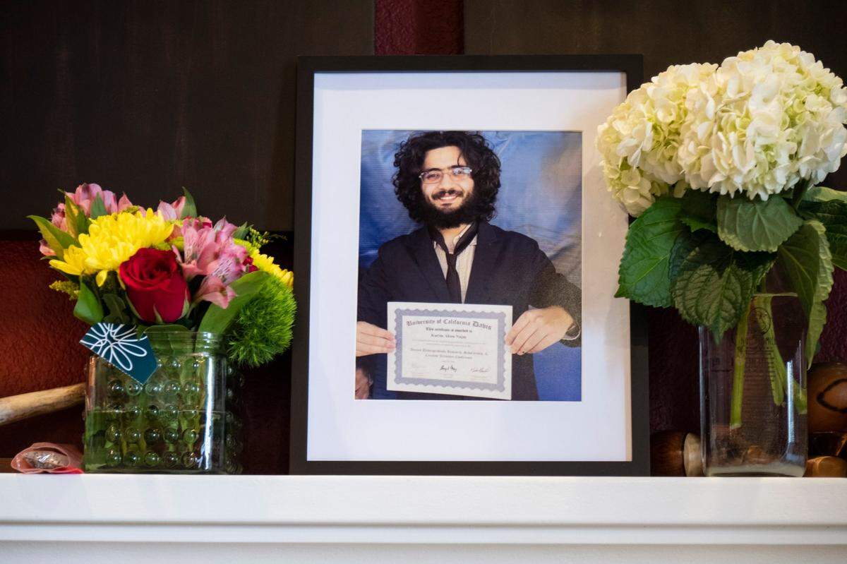 A portrait of Karim Abou Najm stands amid flowers on the fireplace mantel of his family’s home in Davis on Monday. Abou-Najm, a senior at UC Davis and the son of a professor at the university, was fatally stabbed at Sycamore Park on Saturday in an incident similar to a deadly stabbing at the city’s Central Park on Thursday.