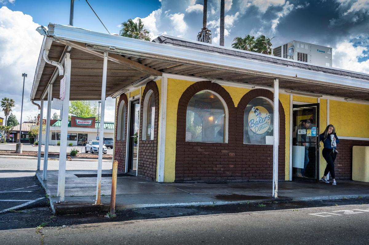 A customer leaves Baker’s Donuts on Florin Road in Sacramento on Monday where Krispy Kreme is seen across the street. The family-owned shop is gearing up for more competition as a third donut shot is expected to open in August.