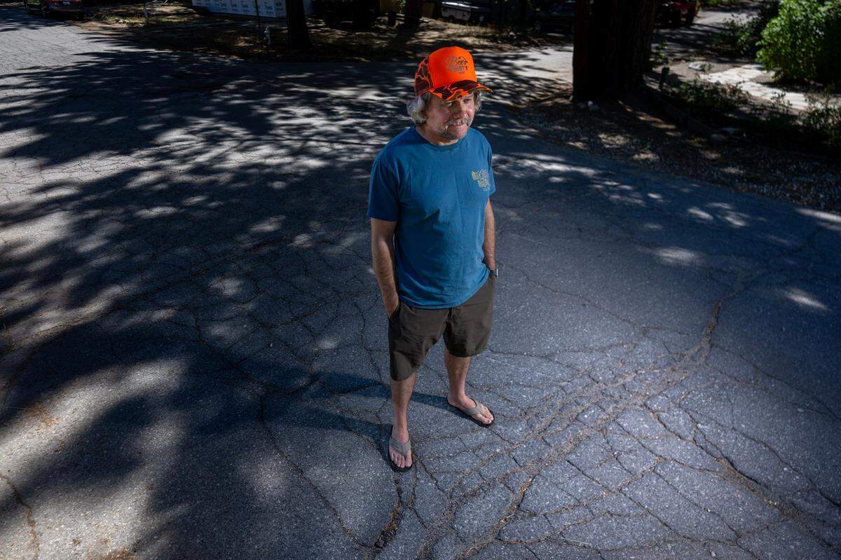 C.T. Rowe stands on the cracked road in front of his home in South Lake Tahoe in August. The 30-year resident says Measure N would bring in revenue to help maintain the town’s basic needs.
