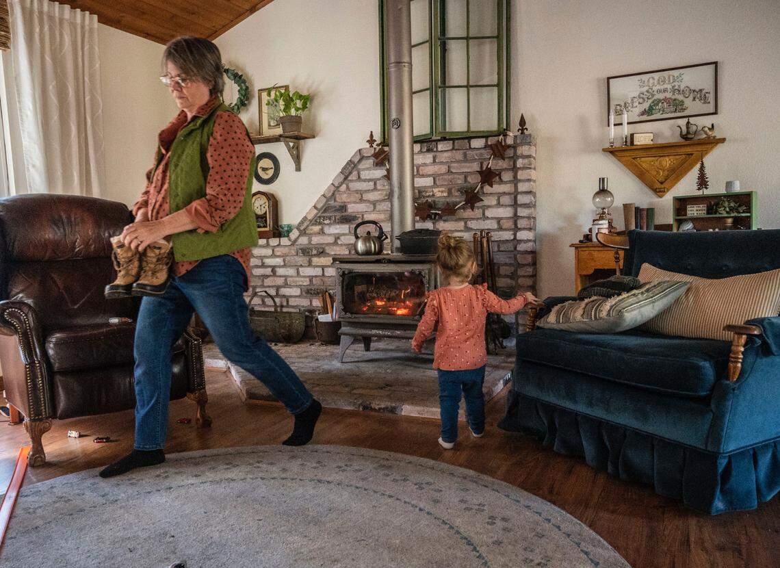 Kim Ummel, de 64 años, se prepara para salir al exterior con su nieta Darcy, de dos años, en Norlene Way, en Alta Sierra, el jueves, ya que los habitantes de la zona de Grass Valley llevan más de una semana sin electricidad tras las fuertes tormentas de nieve. Los Ummel, que se quedaron sin electricidad el 27 de diciembre, están calentando la casa con una estufa de leña.
