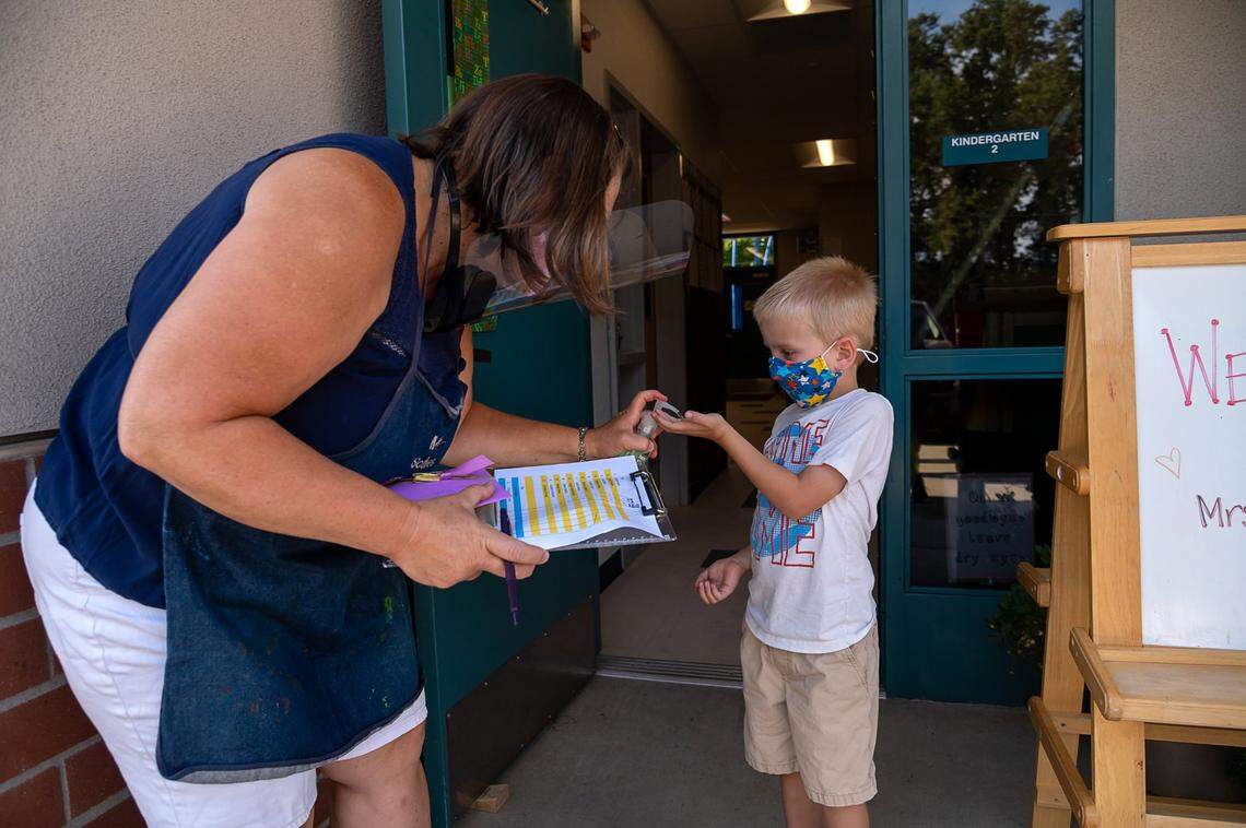Kindergarten teacher Lynn Scales squirts hand sanitizer on Maddox Korb, 5, as he enters her classroom during the first day of school at Rescue Elementary School on Monday, Aug. 17. The school is able to open for in-class instruction because El Dorado County is not on the state’s coronavirus watchlist.