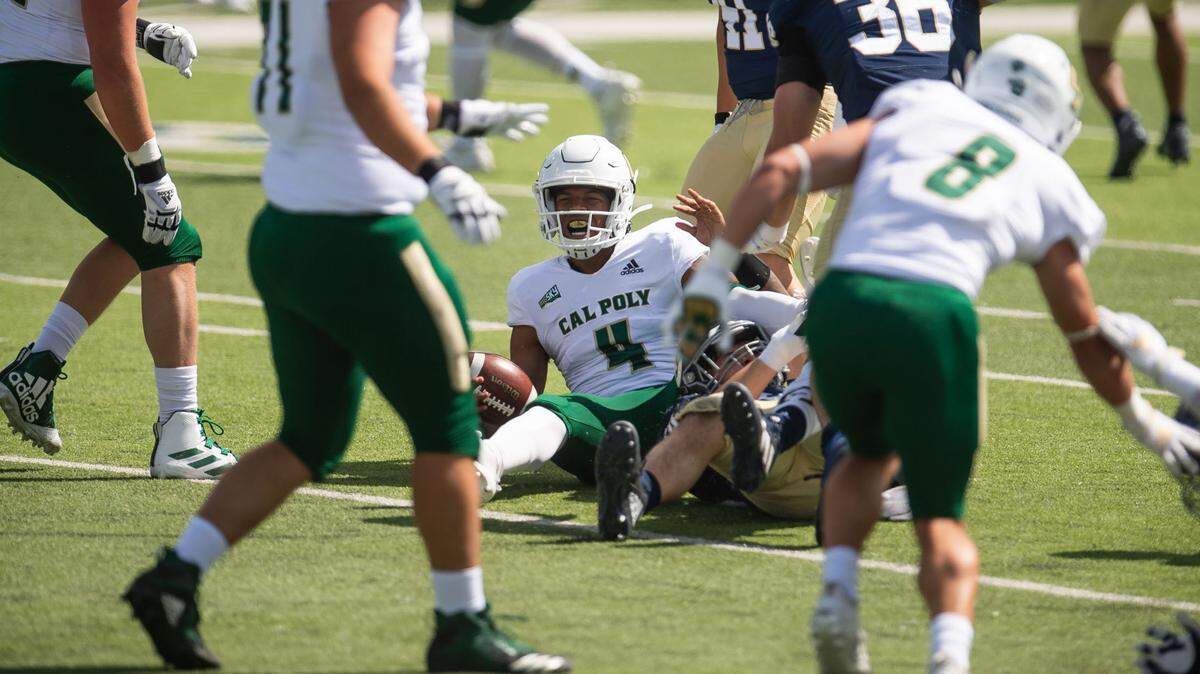 Cal Poly Mustangs quarterback Jalen Hamler is sacked by UC Davis Aggies defensive lineman Cade Peacock (90) during the Aggies’ first home football game of the spring season Saturday, March 20, 2021, in Davis.