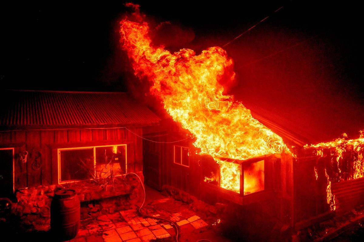 Flames shoot from a window as the Bear Fire burns through the Berry Creek area of Butte County, Calif., on Wednesday, Sept. 9, 2020. The blaze, part of the lightning-sparked North Complex, expanded at a critical rate of spread as winds buffeted the region.