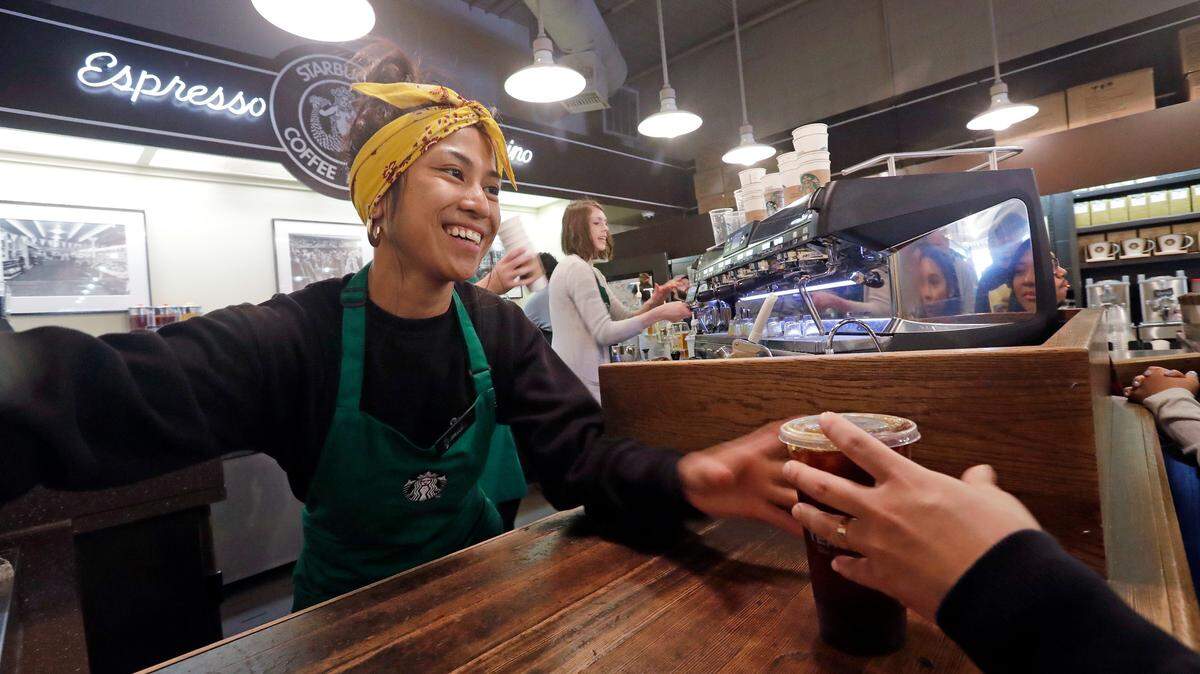 Barista Sarah Dacuno serves a customer at a Starbucks, commonly referred to as the original Starbucks, in the Pike Place Market in May. Starucks and Dunkin’ Donuts are bringing back their pumpkin spice coffees a week early this year.