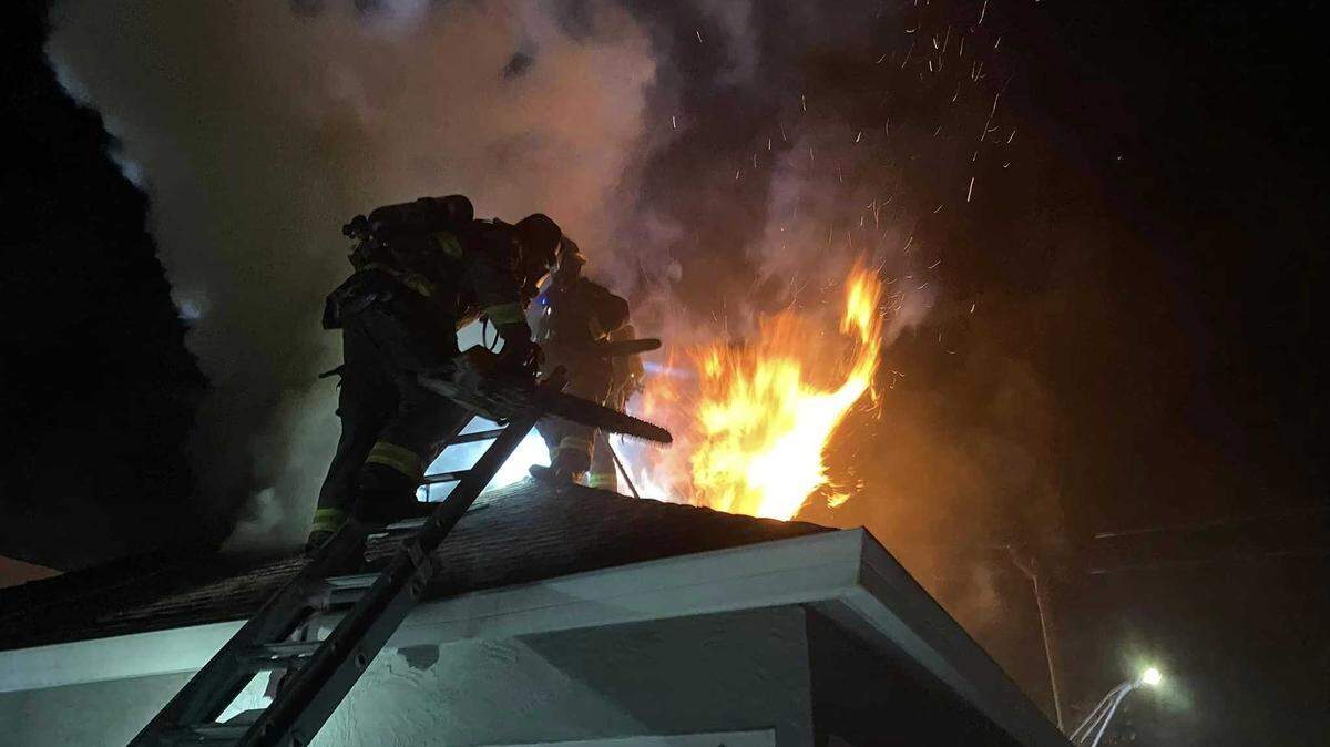 Firefighters cut a hole in a roof at the Gathering Inn homeless services building in Roseville during a fire at the Berkeley Avenue facility on Sunday, Sept. 8, 2024.
