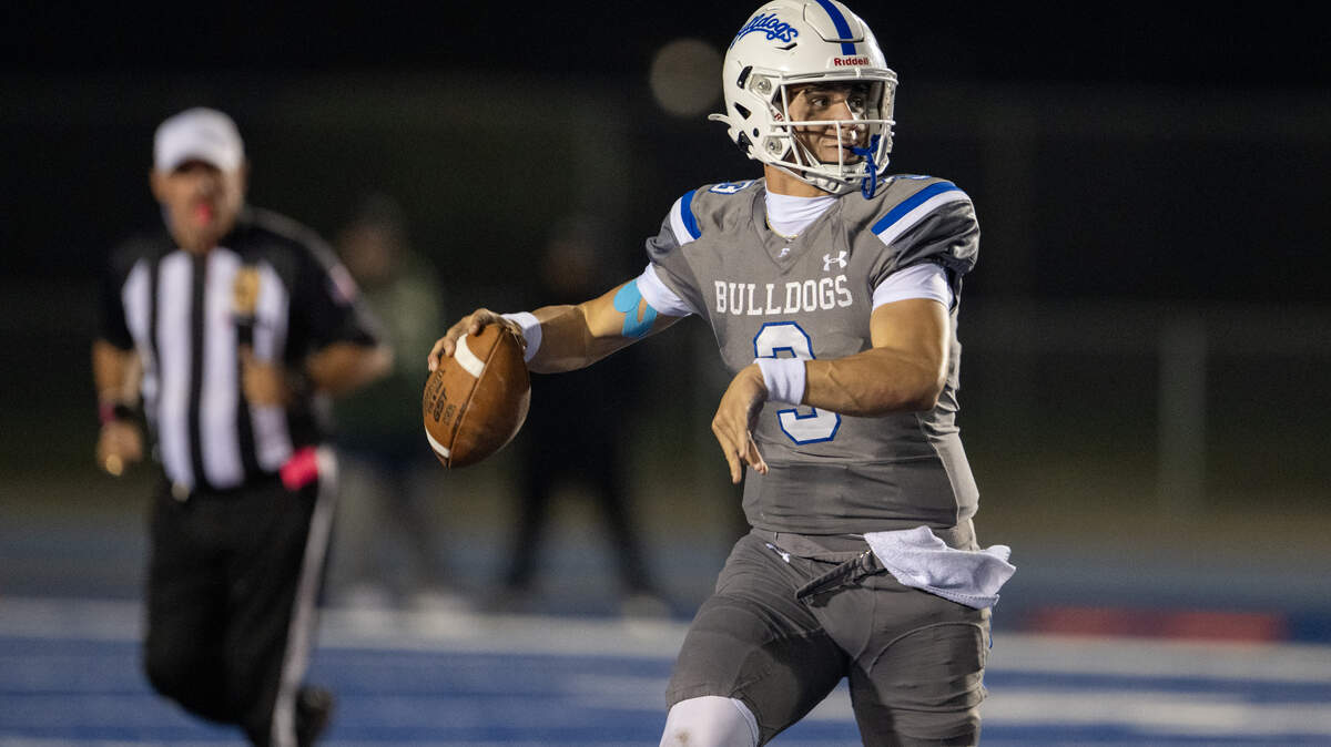 Folsom quarterback Ryder Lyons rolls right before throwing a pass in the second half against the Granite Bay Grizzlies on Friday. The top-seeded Bulldogs will face No. 8 Downey on Nov. 14. 