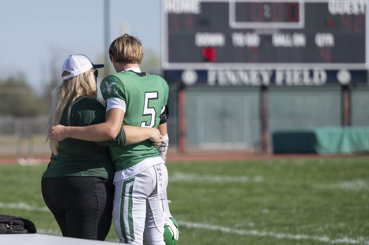 Dixon’s Wesley Besseghini, son of Dixon coach Wes Besseghini, hugs a family member after a varsity football game against Casa Roble in Dixon on Saturday.