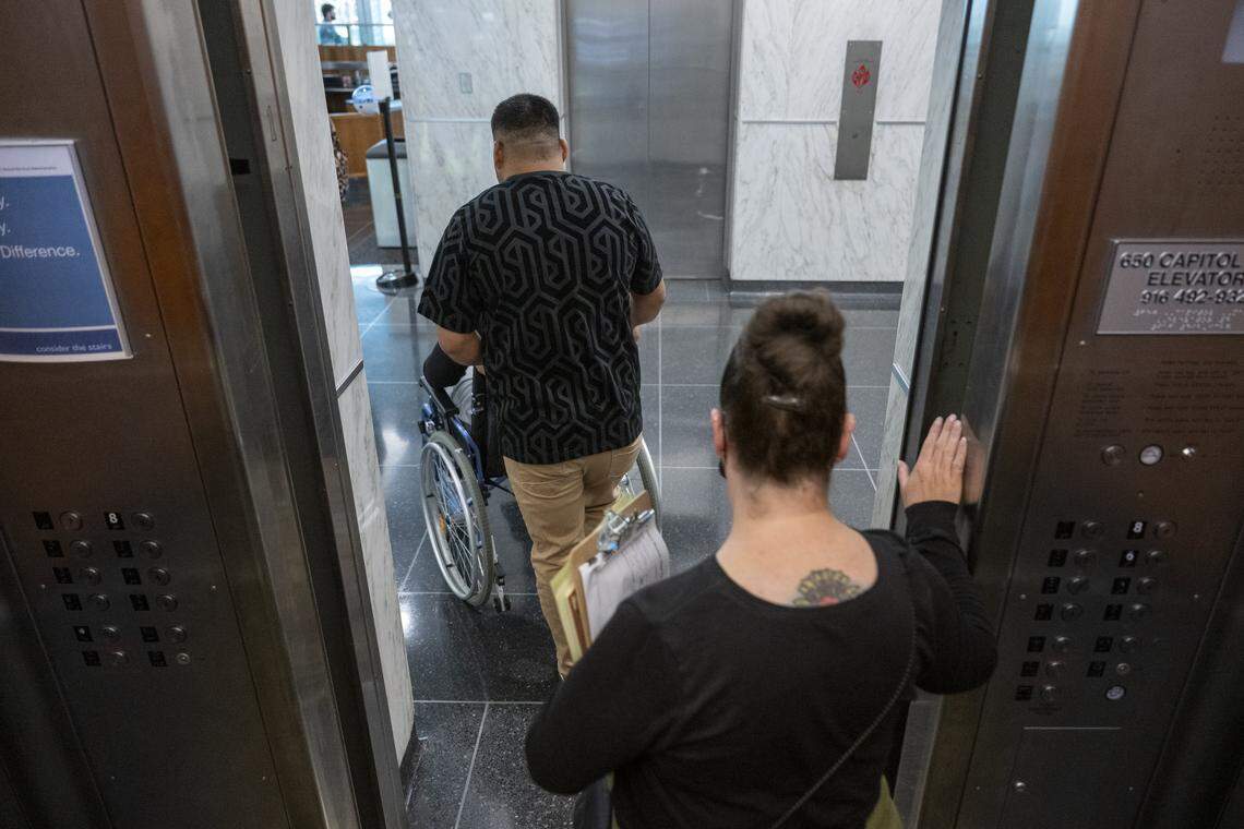 A court volunteer escorts a family out of the John Moss federal building in downtown Sacramento after an immigration court hearing on July 22.
