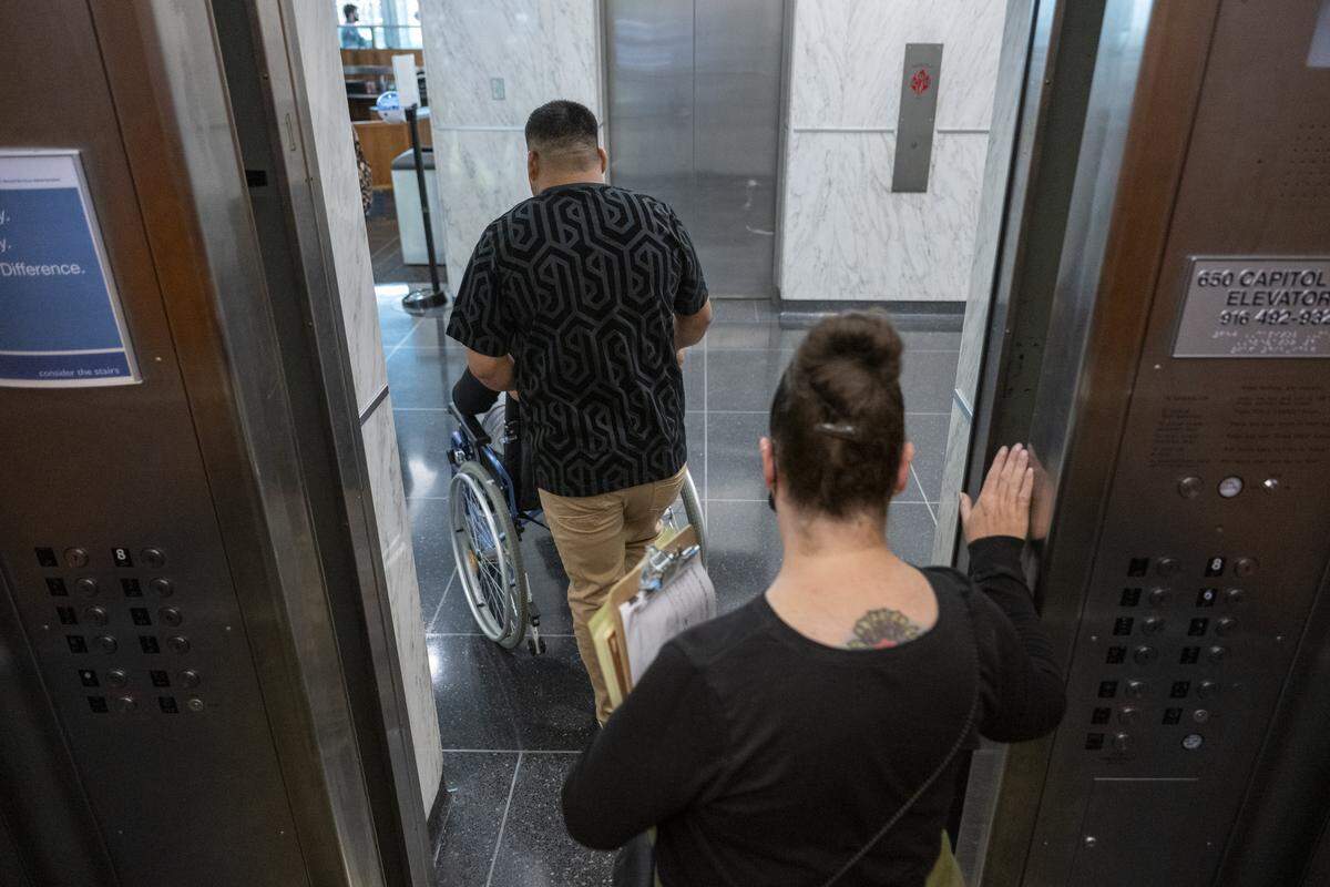A court volunteer escorts a family out of the out of the John E. Moss federal building in downtown Sacramento after an immigration court hearing on July 22.