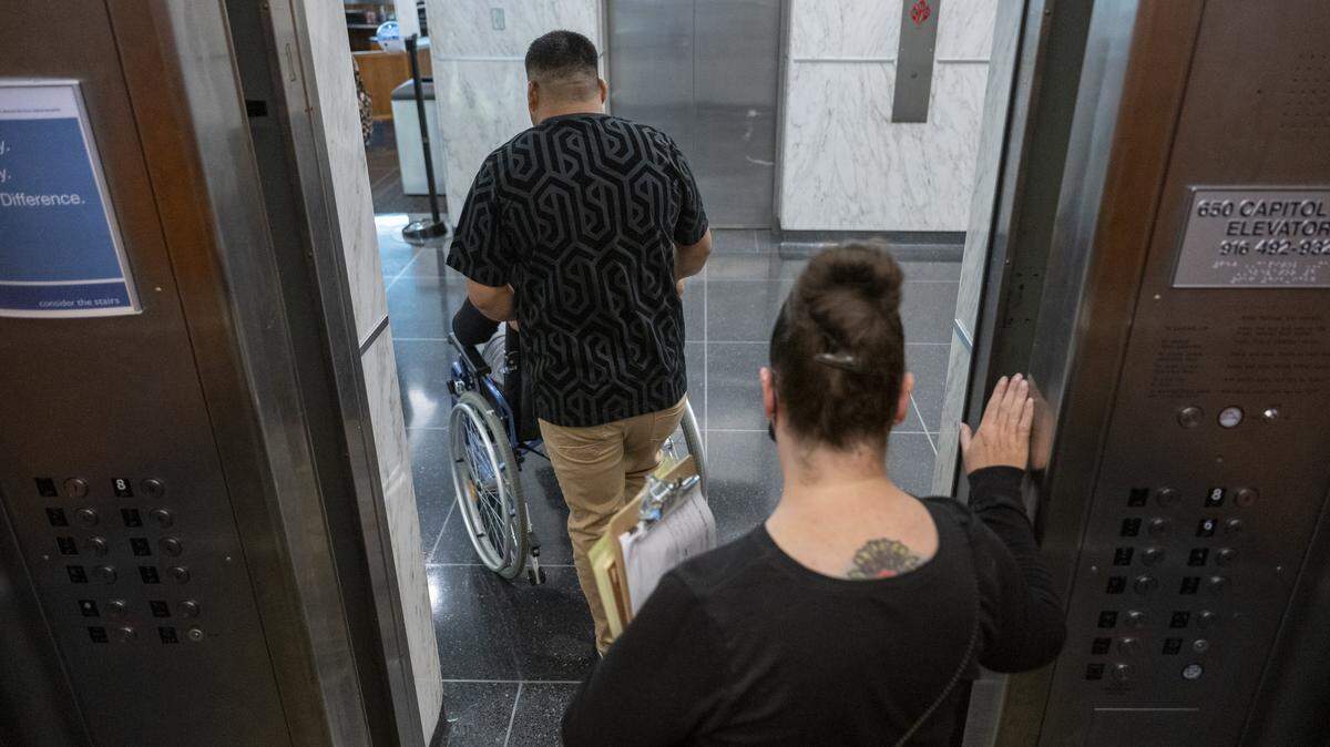A court volunteer escorts a family out of the out of the John E. Moss federal building in downtown Sacramento after an immigration court hearing on Tuesday, July 22, 2025.