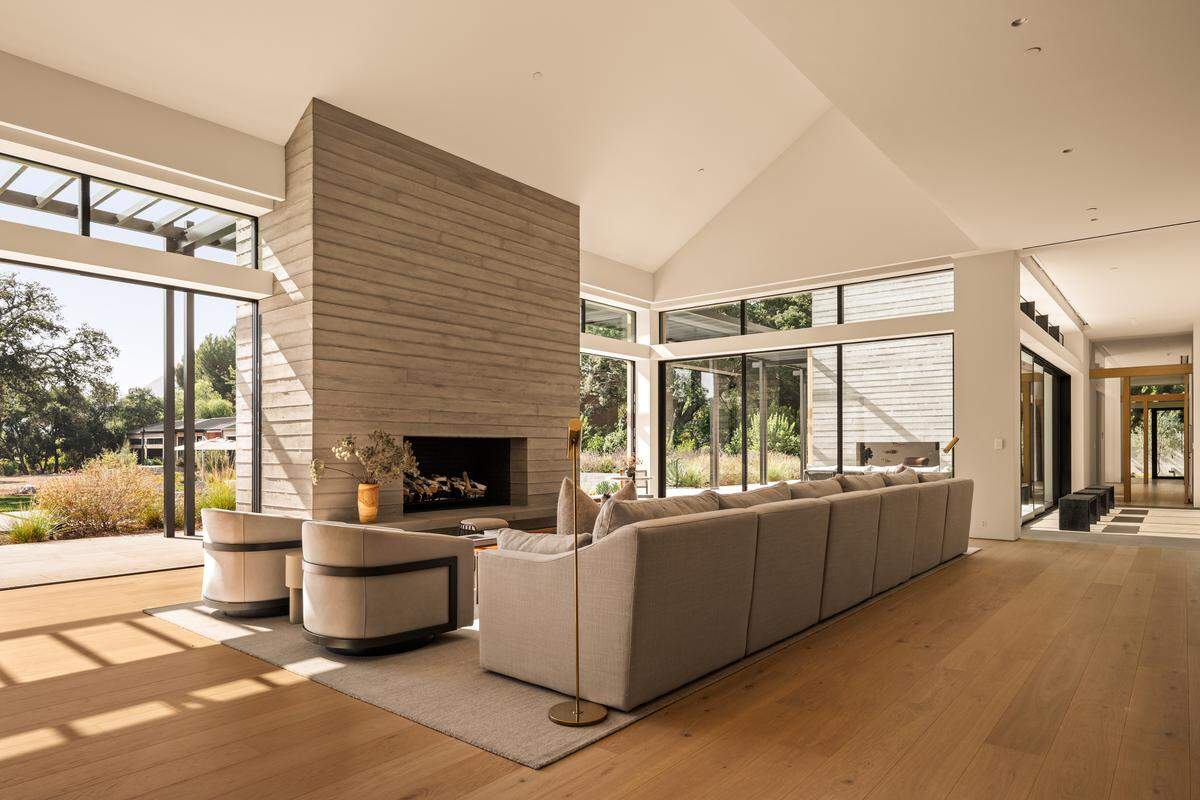 A dramatic 12-foot pivot door welcomes you to airy interiors filled with natural light and spectacular zen-inspired views of olive trees and native landscaping.