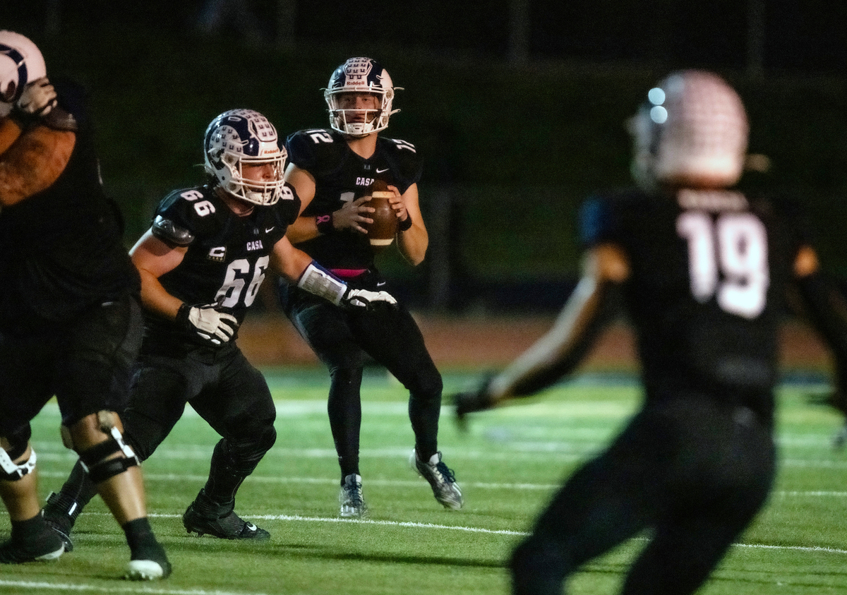 Casa Roble Rams quarterback Connor Campbell (12) looks downfield to find receiver Ethan Horner for a 72-yard touchdown pass in the first quarter against the Pioneer Patriots on Friday, Oct. 20, 2023, at Casa Roble High School in Orangevale.