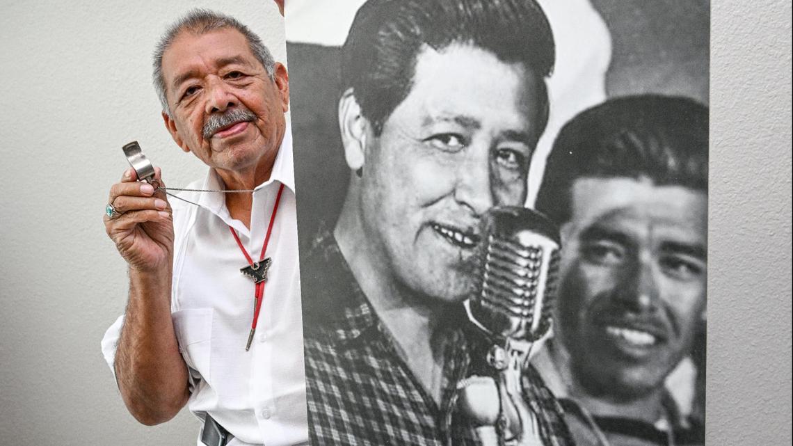 Roberto Bustos, de Tulare, más conocido como "El Capitán" durante la famosa marcha de United Farm Workers en 1966, sostiene el silbato que usó para organizar a los seguidores de la marcha y una foto suya con el líder de UFW, César Chávez, en su casa el sábado.