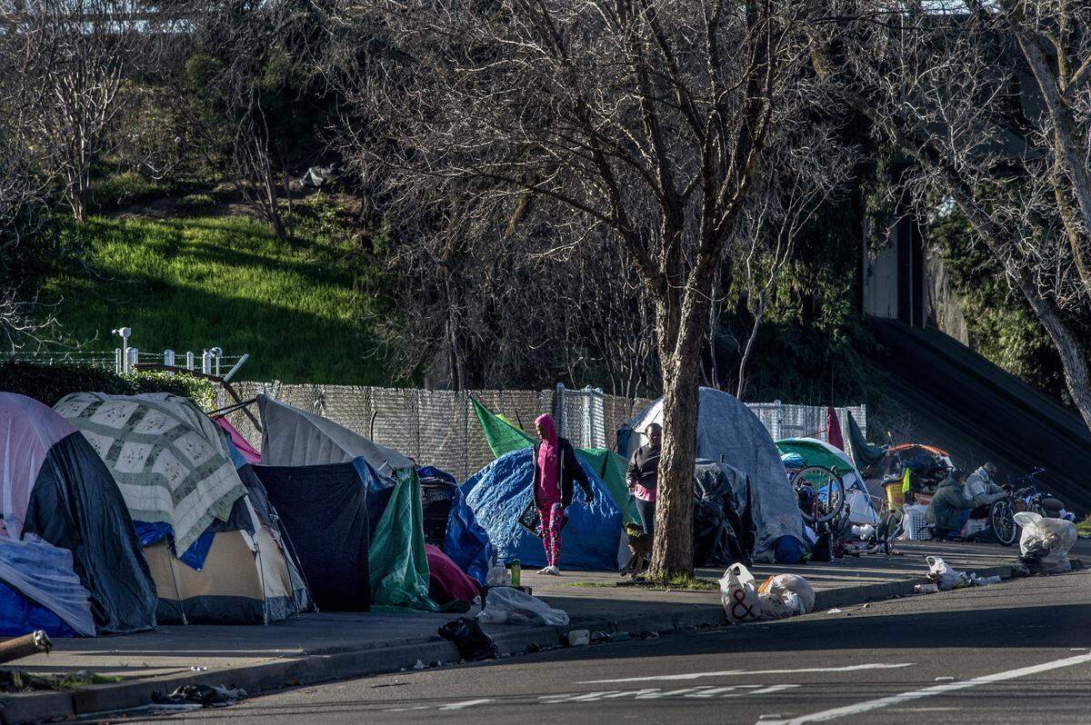 Lois Caesar, 57, wearing pink, says she is looking forward to moving into a shelter. Caesars tent is one of about 15 that now line X Street, on Thursday, Jan. 2, 2020, just outside a recently-paved lot where the city plans to open a 100-bed shelter in May.