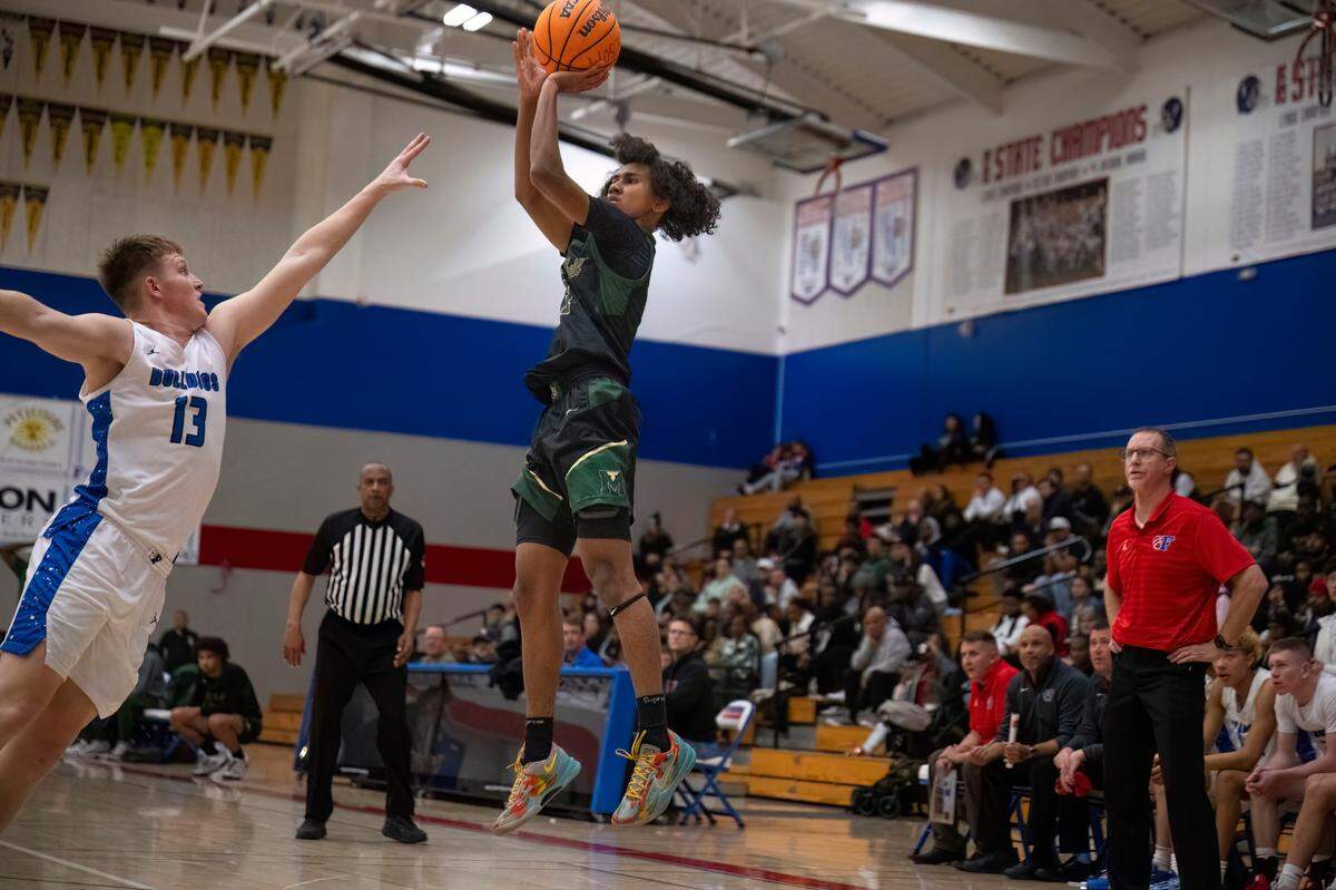 Monterey Trail Mustangs guard Rashawn Inglemon (1) takes a jump shot as the Folsom Bulldogs’ Kaiser Bowen (13) defends during a boys basketball game in Folsom on Saturday.
