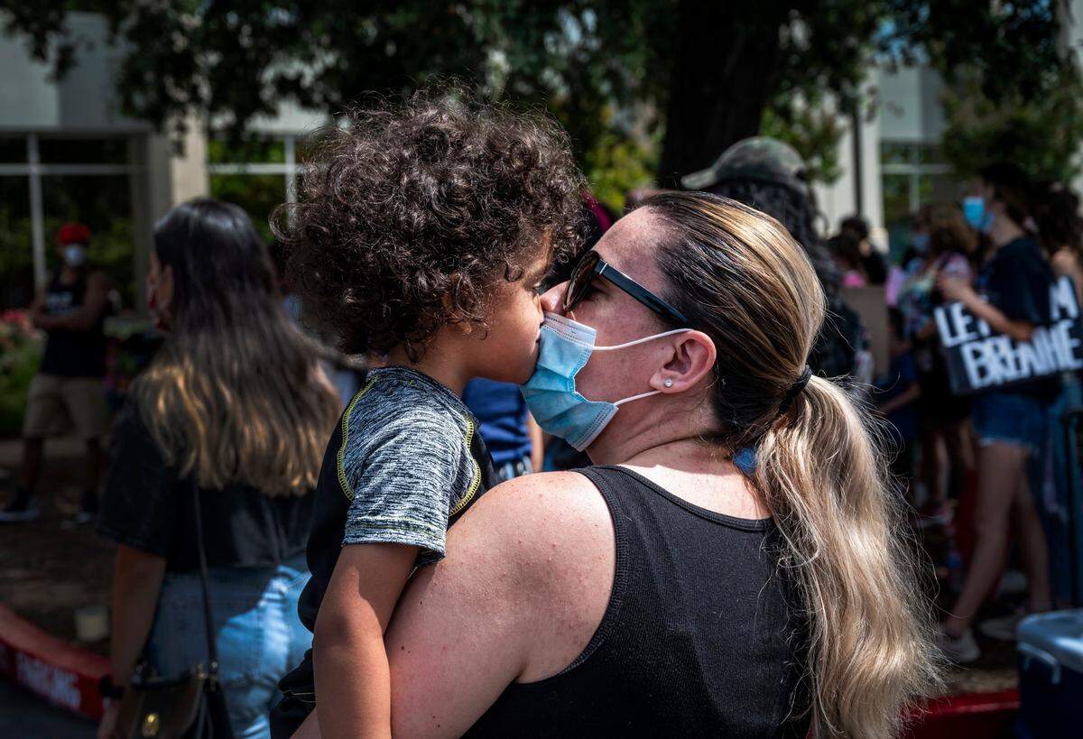 Sarah Standfield of Elk Grove kisses her son Elijah, 4, through a face mask during a peaceful protest in Elk Grove for George Floyd on Wednesday, June 10, 2020.