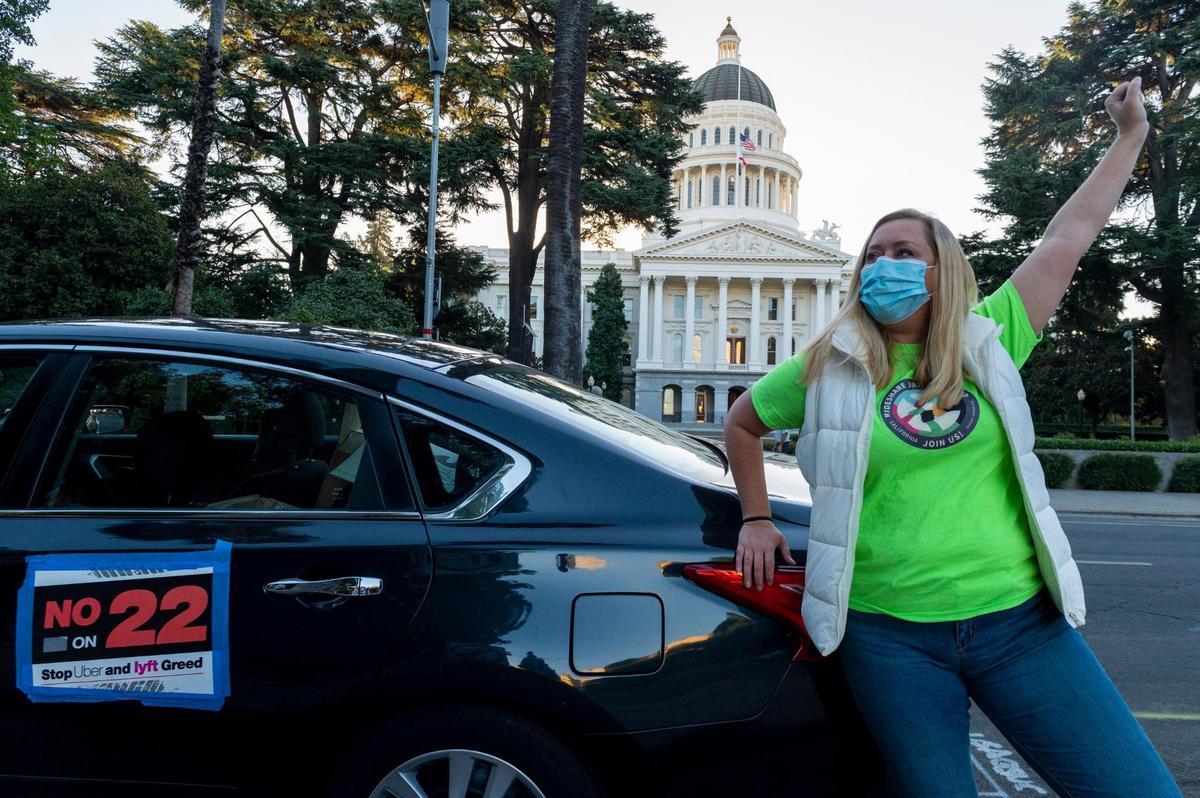 Erica Mighetto, an Uber and Lyft driver, demonstrates at the Capitol at a gig workers rally against Proposition 22, the most expensive ballot initiative in state history, before its passage in 2020. The initiative exempted app-based transportation and delivery services from Assembly Bill 5, allowing them to continue to employ drivers as independent contractors. “It sends the message that large companies can buy laws,” said Mighetto.