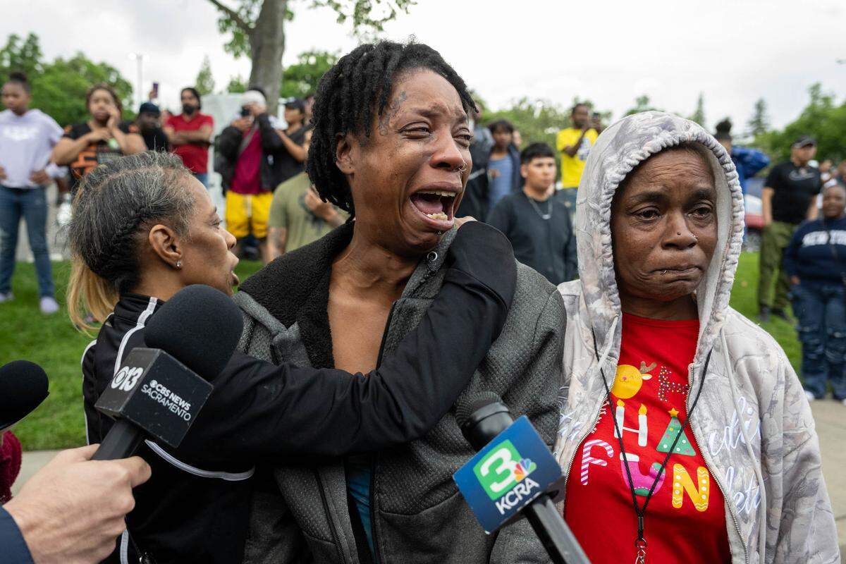 Family members of the shooting suspect call for him as law enforcement officers demand his surrender after a shooting at Natomas High School that left one student dead on Friday. Authorities searched for the suspect at the Natomas Village apartments near the campus.