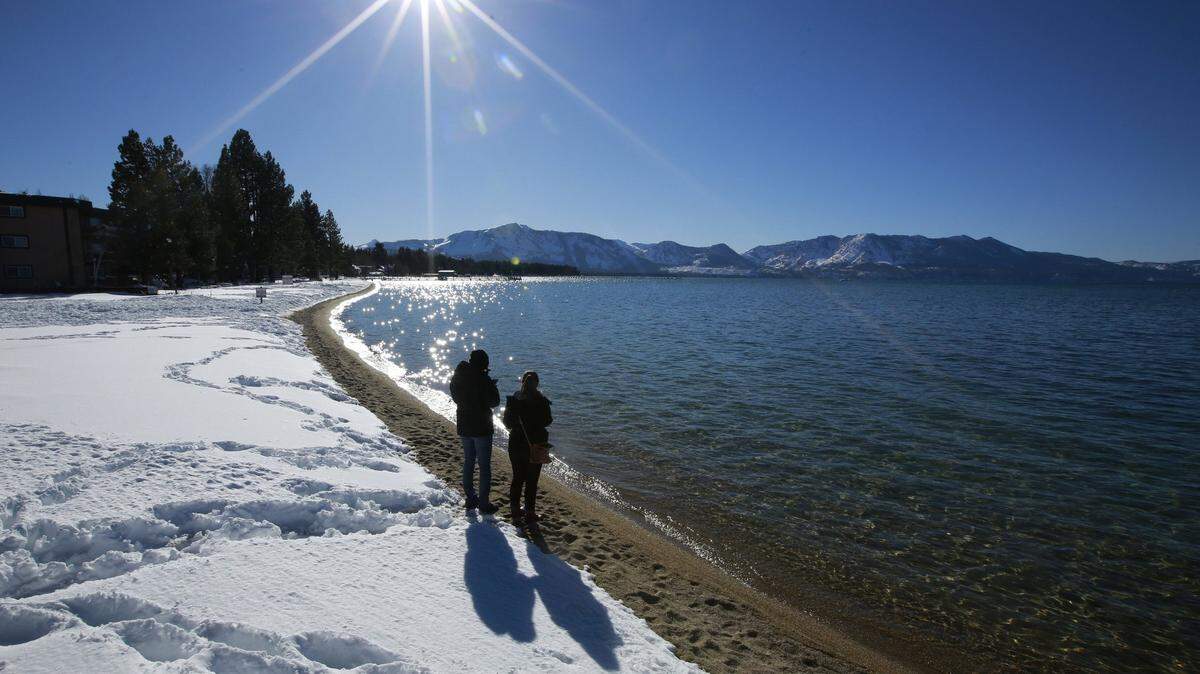 In this March 5, 2018, file photo, sunlight shimmers off the snow and waters of Lake Tahoe.