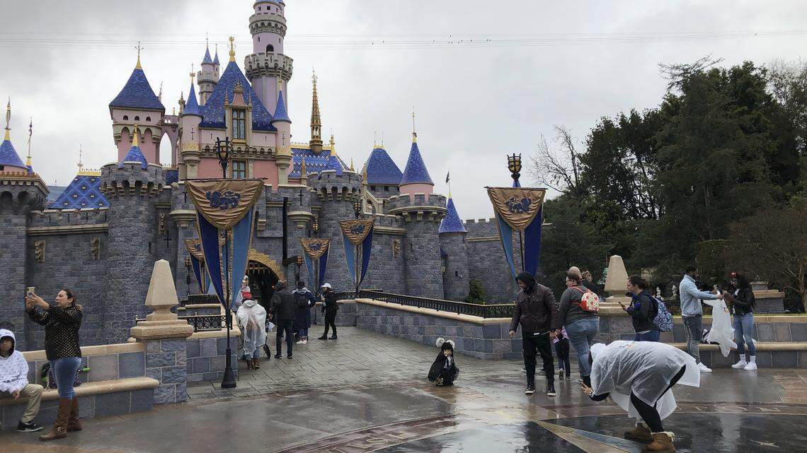 Visitors take photos at Disneyland in Anaheim, Calif., Friday, March 13, 2020. Disneyland has been closed since March because of the coronavirus.