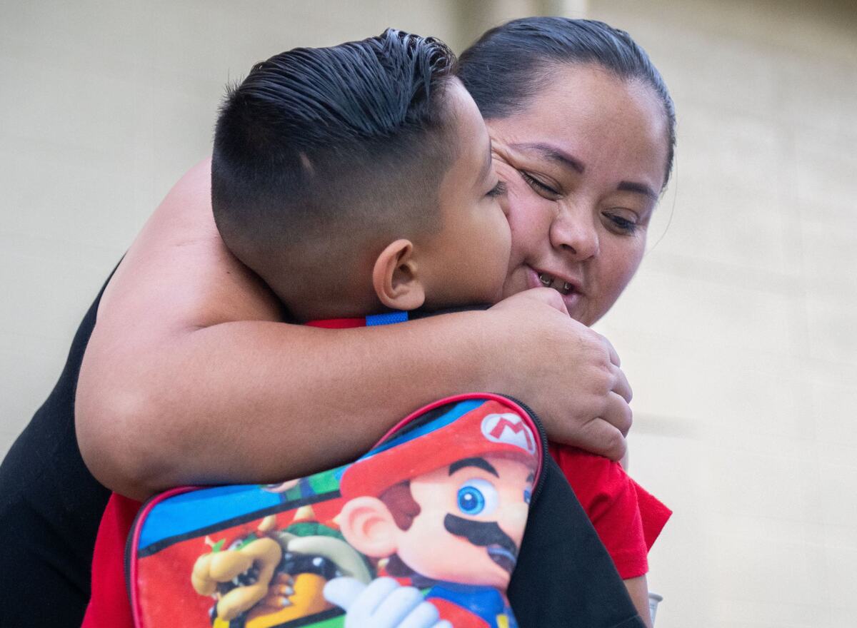 Maria Cruz, back, hugs her son, Gustavo Pio-Cruz on the first day of classes at Williamson Elementary School in Rancho Cordova on Thursday. Cruz said she’s feeling excited for Pio-Cruz to start first grade, but she’s also a little sad because she’s not sure how he will adjust to the scholastic environment.