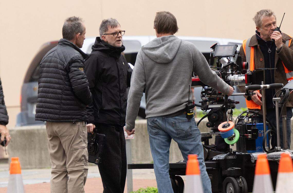 Director Paul Thomas Anderson, second from left, confers with crewmembers during the production of “One Battle After Another” in downtown Sacramento in Feburary 2024. 
