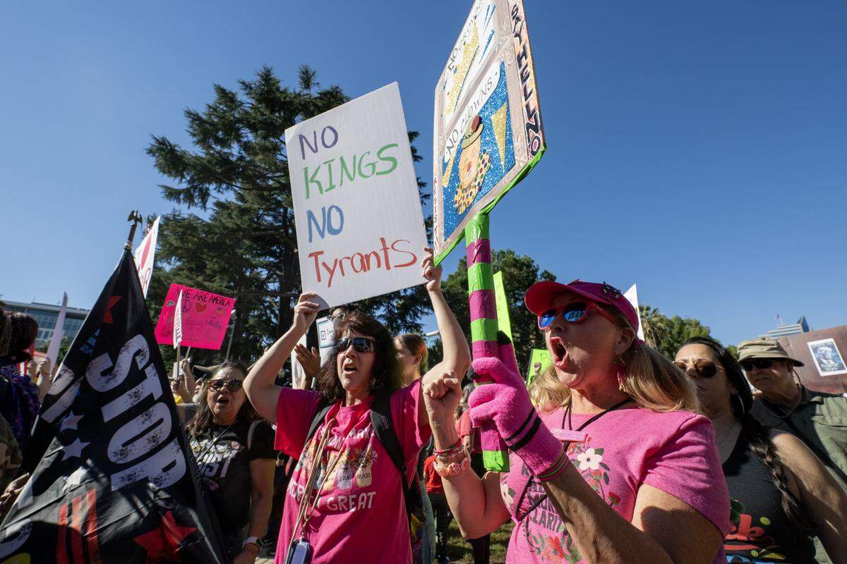 Jessica Brown and Katee James, of Elk Grove, stand with Crystal Owens of Sacramento during the "No Kings" protest at the state Capitol in Sacramento on Saturday, Oct. 18, 2025.