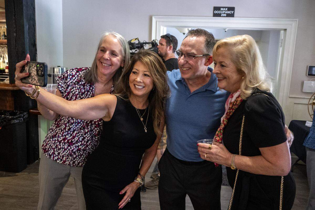 Risa Omega takes a photograph with Michelle Gaskill, Kevin Hale, and Jennifer Smith at the Dick Cable remembrance at The Invitation Room in Old Sacramento on Saturday.