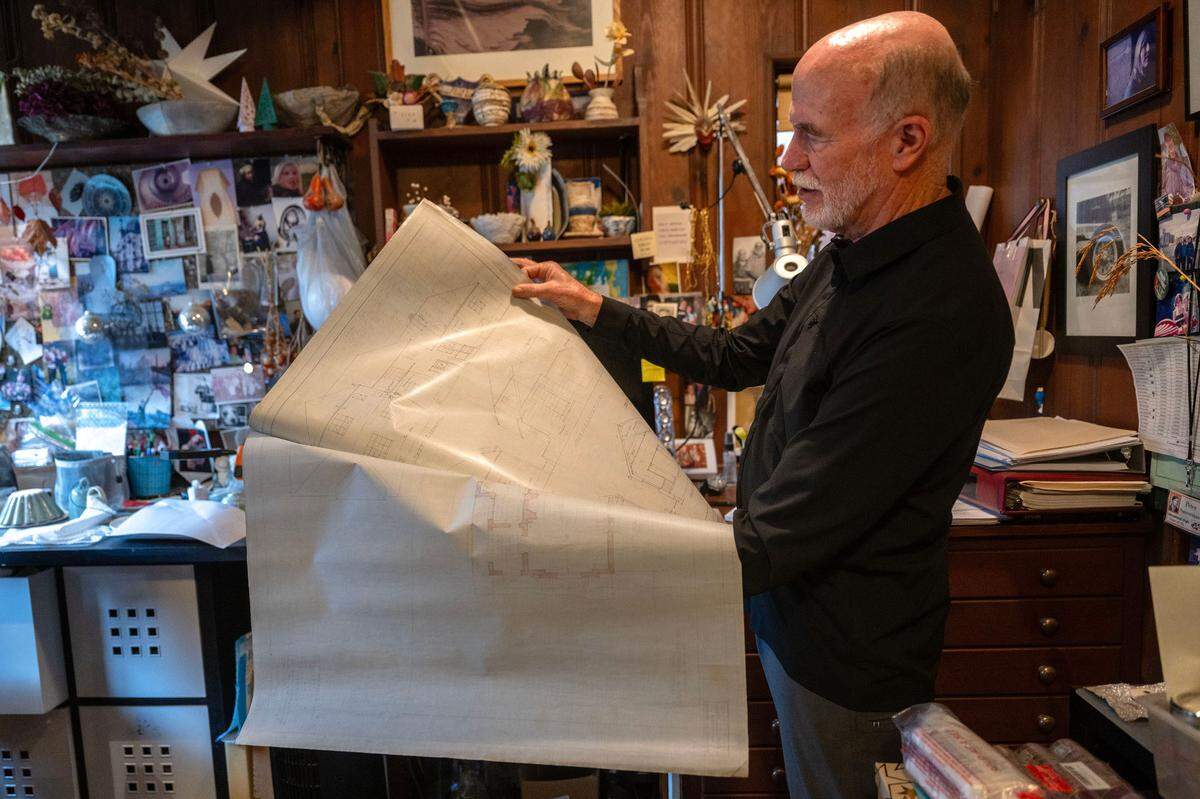 Peter Saucerman holds earlier this month architectural drawings by Leonard F. Starks that remained in his home after his death in 1986. Saucerman, who is also an architect, said he once taught a class on the meticulous drawings by Starks, never imagining he would own the architect’s home and his own set of drawings.