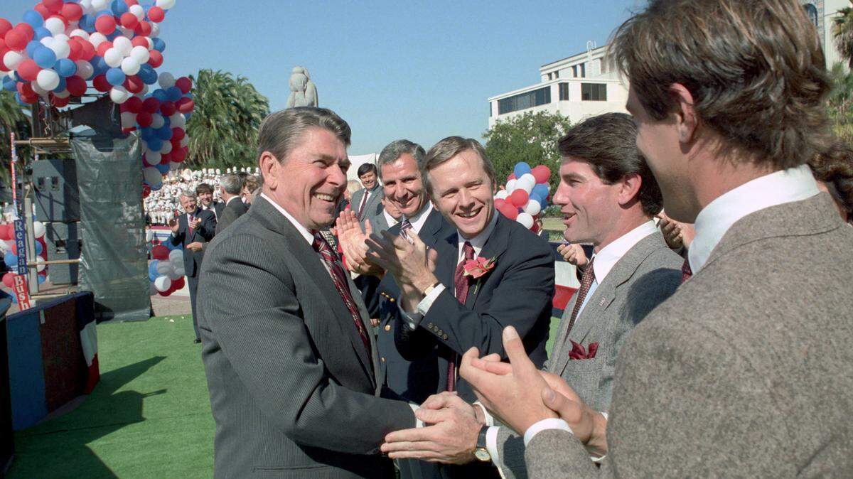President Ronald Reagan shakes hands with baseball player Steve Garvey before a campaign rally at the San Diego County Administration Center on Oct. 22, 1984. California Gov. George Deukmejian, center, and Sen. Pete Wilson applaud.