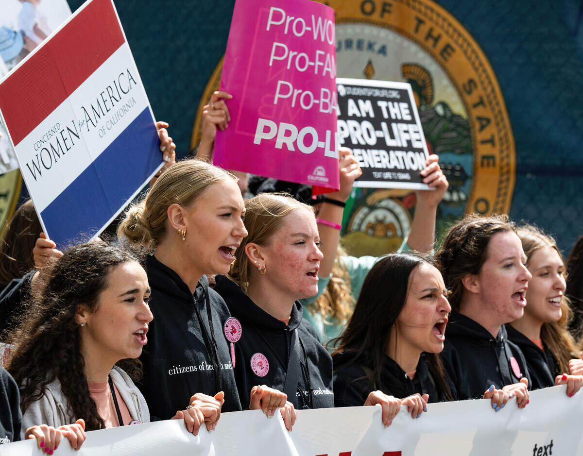 California Baptist University students, from left, Tori Hitchcock, 21, Olivia Ozenbaugh, 19, and Grace De Mars, 21, led the March for Life down L Street near the California Capitol on Monday.