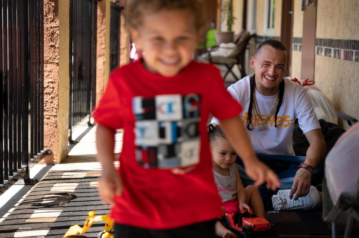 Single father Jedadiah Jincks, 27, plays outside Wednesday with his son Josiah, 3, and daughter Jocelyn, 1, at the city-run motel where they’re living.
