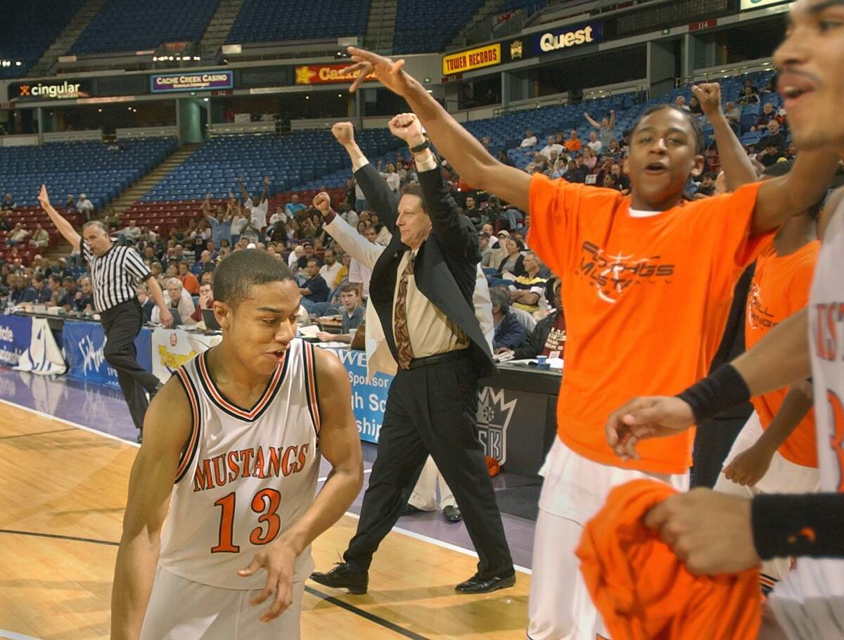 The Foothill High School Mustangs basketball team celebrates its victory over the Archbishop Mitty Monarchs in the Division III regional final at Arco Arena on March 15, 2003. Sam Kirb, left, scored a game-high 17 points and coach Drew Hibbs is at center.
