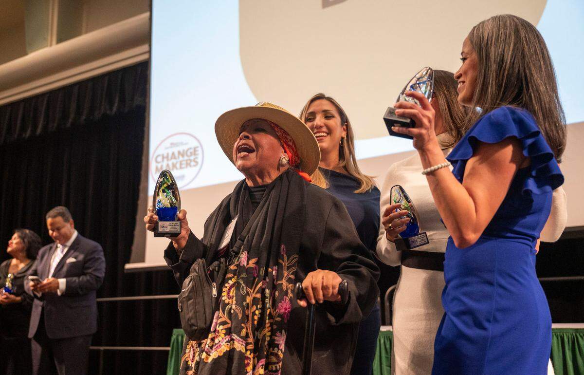 Latino Change Maker Juanita Polendo Ontiveros, center, celebrates on stage with Lisa Cardozo, right, and others as The Sacramento Bee’s Equity Lab and the Nehemiah Emerging Leadership Program hosted the latest 60 leaders at an event held at Sacramento State on Friday night.