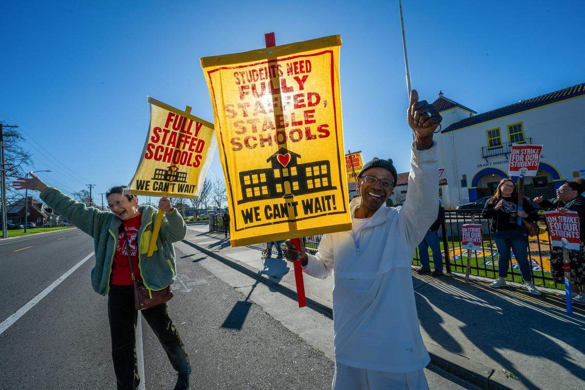James Van Buren, right, a special education teacher and drum line instructor, and Rebecca Henry, left, a curriculum support teacher, strike with Twin Rivers Unified School District teachers in front of Grant High School in Sacramento on Thursday.