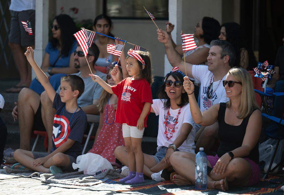 Julia Trejo, 3, center, waves the American flag during the Folsom Historic Parade on Sutter Street on Saturday in Folsom.
