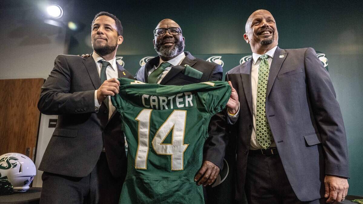 New Sacramento State football coach Alonzo Carter stands alongside university president Luke Wood, left, and athletic director Mark Orr during his introductory news conference on Dec. 18, 2025.