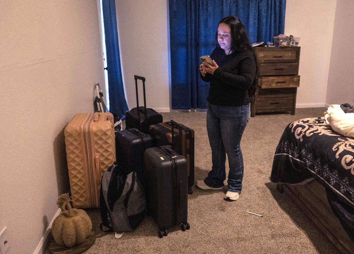 Sacramento resident Damaris Bello takes a phone call as she stands by suitcases on Friday filled with her mother’s belongings. Bello’s mother was deported on Wednesday after attending an immigration appointment to change her DACA status.
